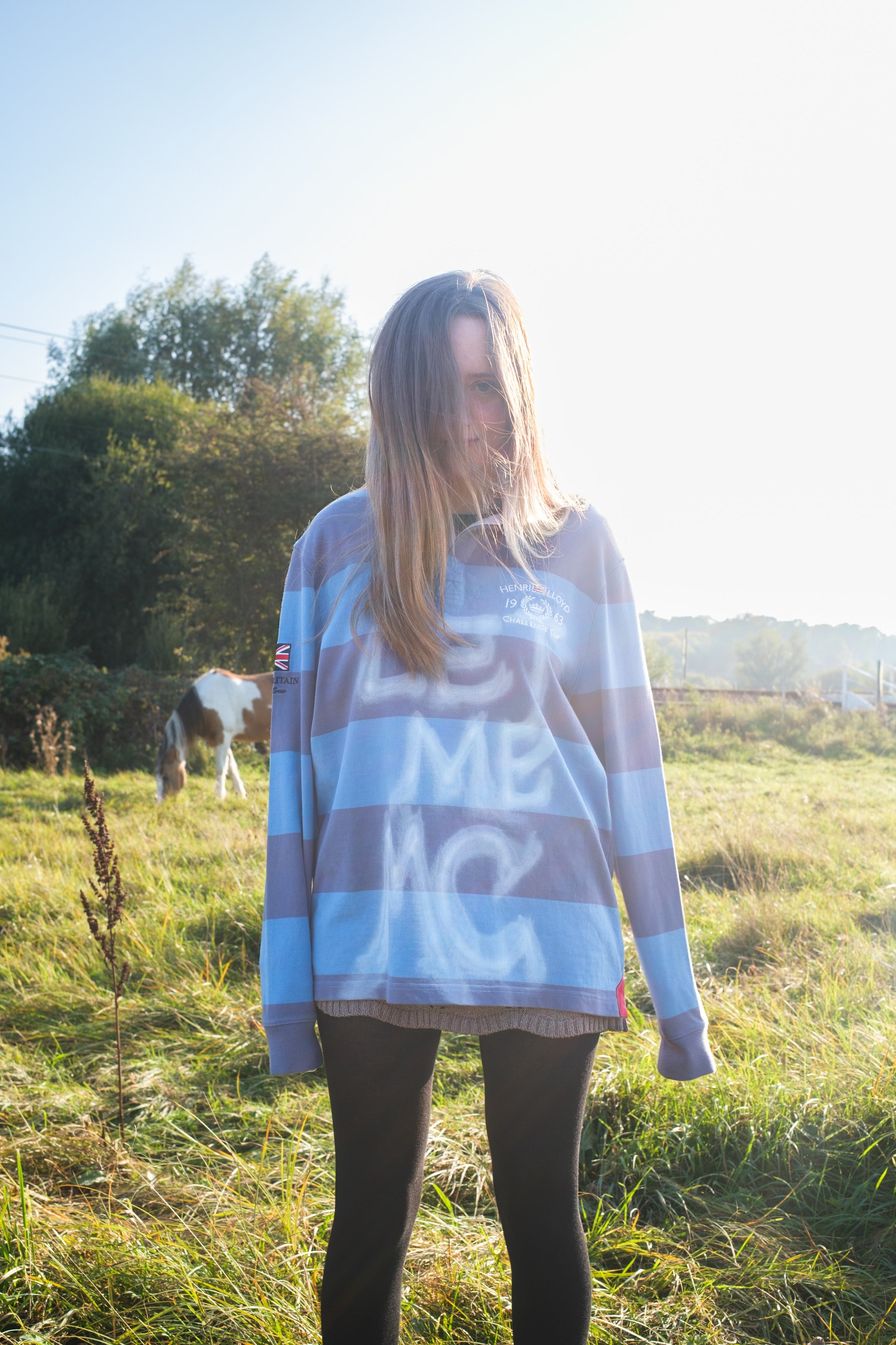 Person wearing a striped sweater with text in an outdoor setting