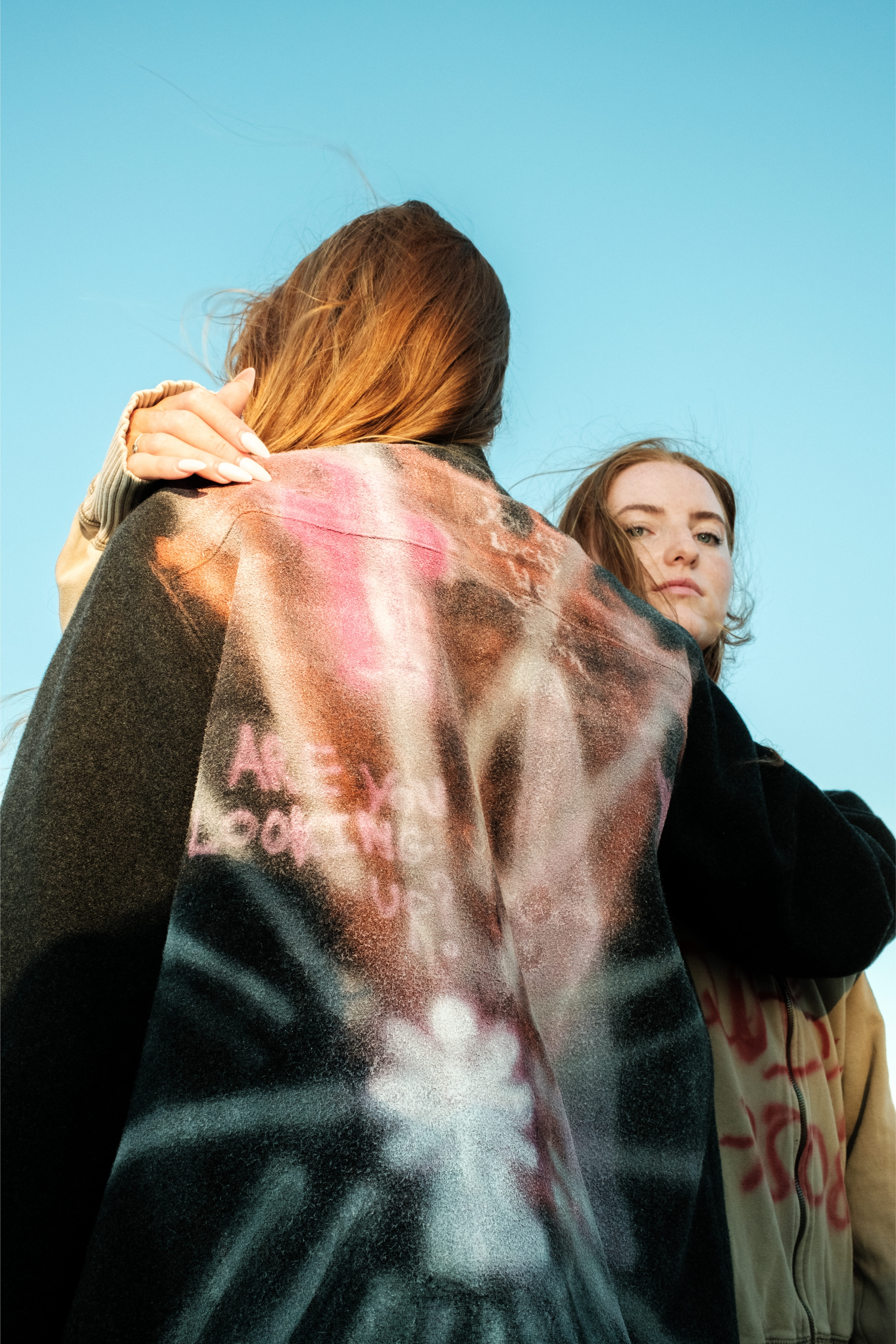 Back view of painted coat with pink and white spray design, Bewept Bag of Man collection.