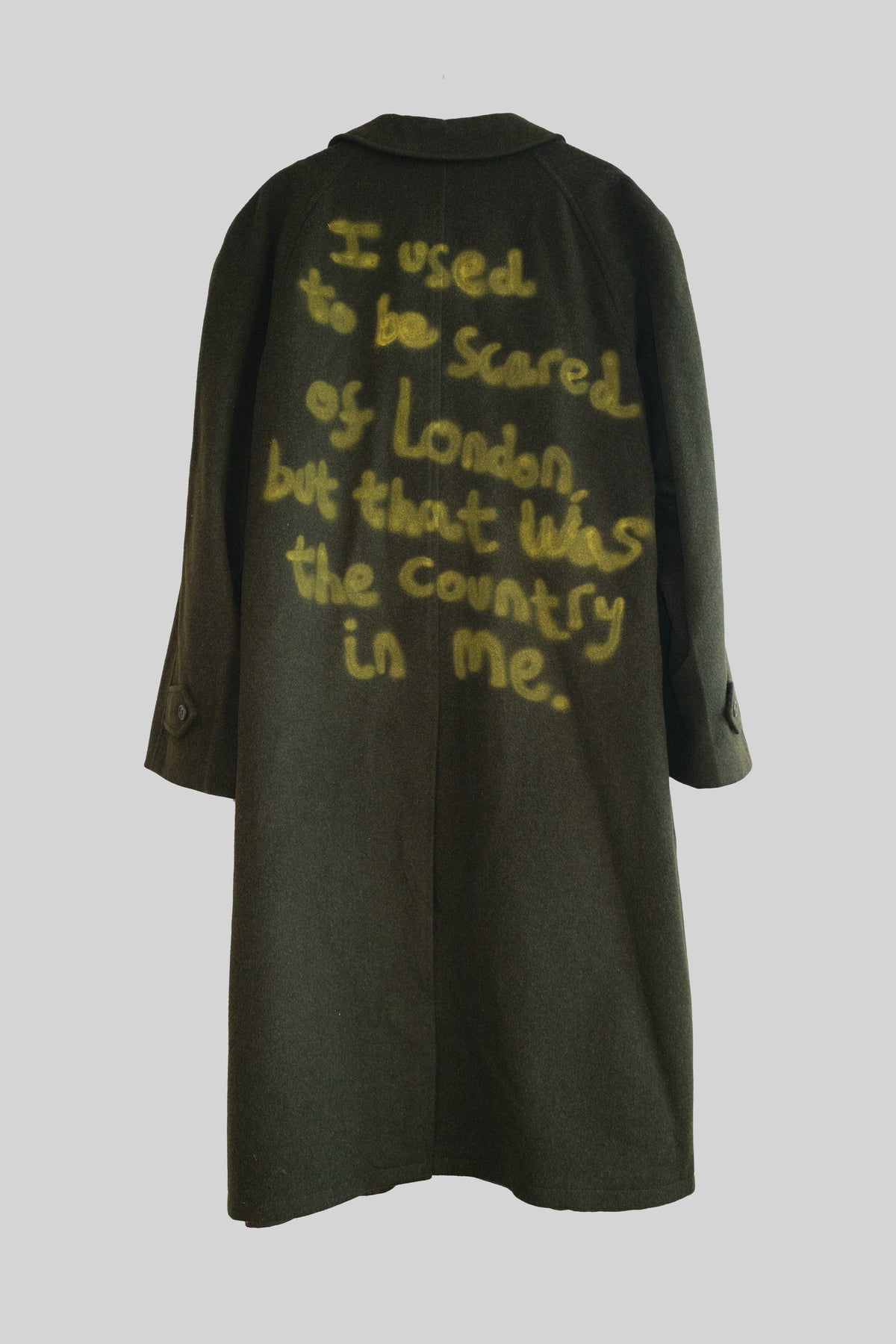 Dark green coat with yellow text on a light gray background