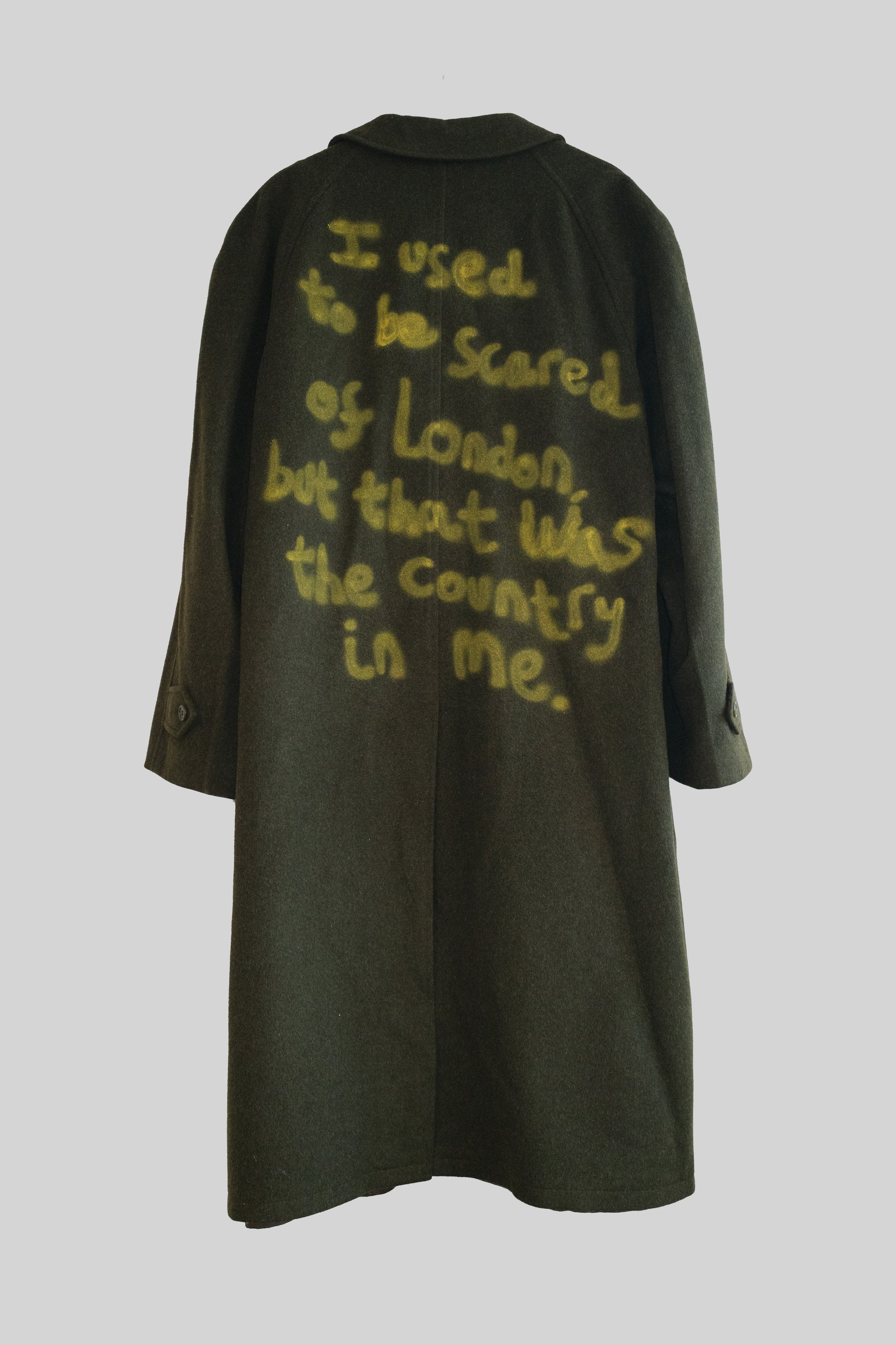 Dark green coat with yellow text on a light gray background