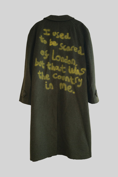 Dark green coat with yellow text on a light gray background